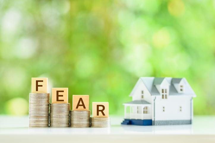 Common Home Or Mortgage Loan Fear Of First Time Buyers, Financial Concept : Coins With The Words FEAR, A Model House On A Table, Depicting Fear Of Housing Bubble And Recession After Interest Rate Hike.
