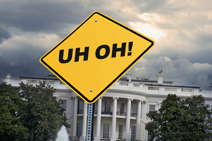 A Road Sign Stands In Front Of The White House That Sits Underneath A Stormy Sky That Simply States, Uh Oh!