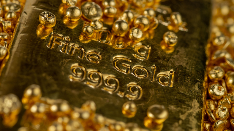 Gold Bar In A Pile Of Gold Granules. Selective Focus.