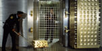 Security Guard With Gold Ingots By Open Vault Door